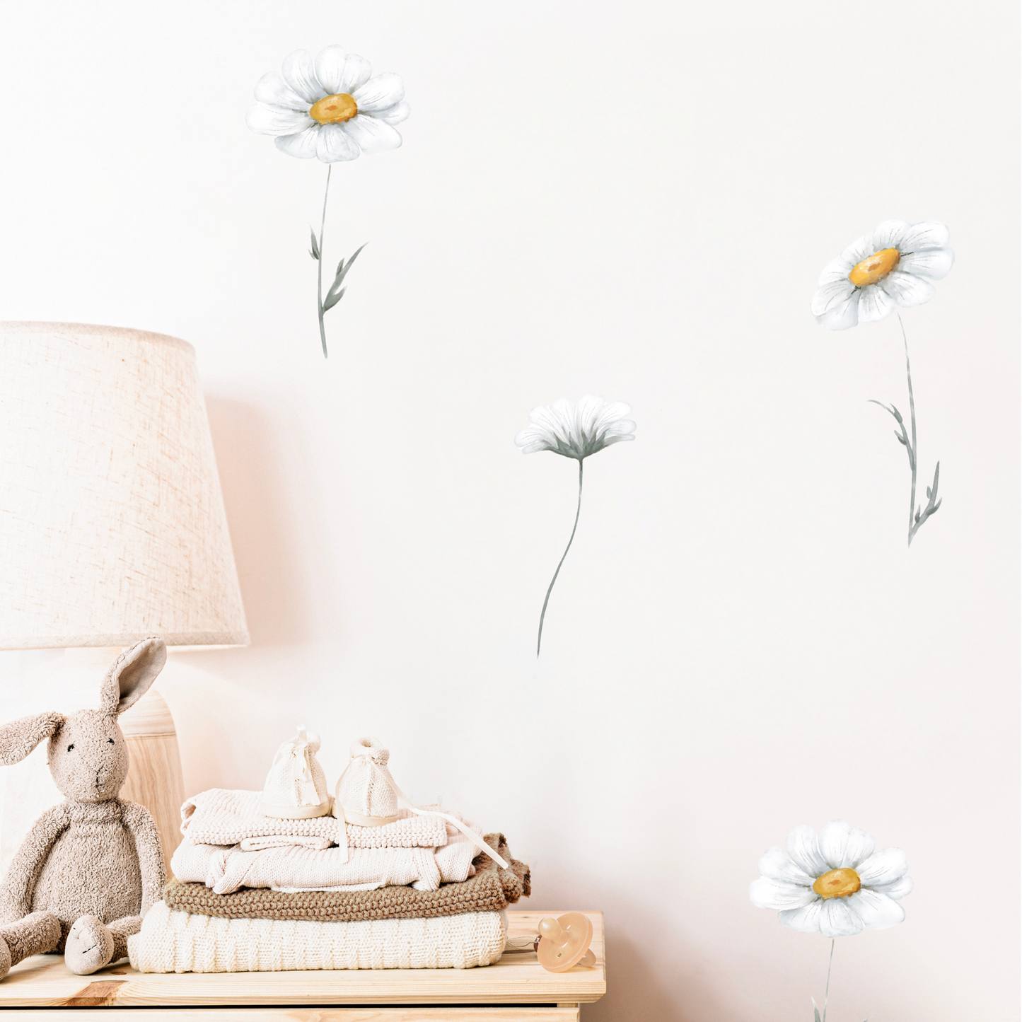 Children's room with a lamp, teddy bear, and folded clothes on a table, decorated with daisy wall stickers. Non-toxic, eco-friendly, reusable fabric wall stickers. Australian made.