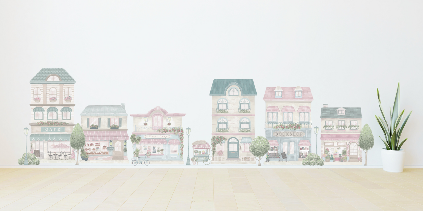 Little Village wall decals on a child's playroom wall.  The town features a house, bookshop, café, florist, bakery, dress shop as well as trees, bushes, a bike and ice-cream cart.  Non-toxic, eco-friendly, reusable wall stickers. Australian made.