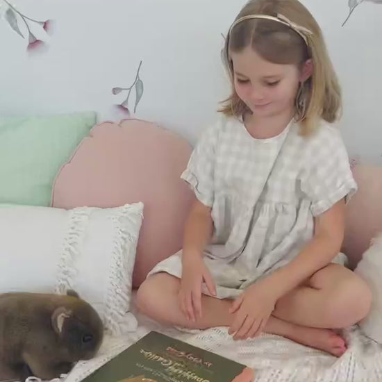 A video of a little girl seated in front of a wall adorned with pink eucalyptus gum blossom decals. Non-toxic, eco-friendly, reusable wall stickers. Australian made.