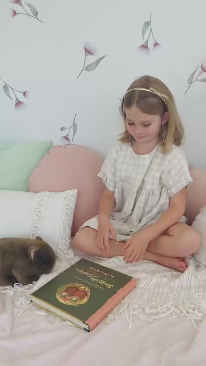 A video of a little girl seated in front of a wall adorned with pink eucalyptus gum blossom decals. Non-toxic, eco-friendly, reusable wall stickers. Australian made.